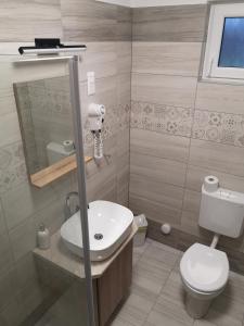 y baño con lavabo blanco y aseo. en Vidéki-Báj Vendégház, en Szentgyörgyvölgy