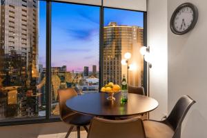 una sala da pranzo con tavolo, sedie e una grande finestra di Opulent Level 25 Condo with Breathtaking Views a Melbourne