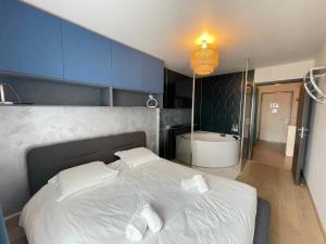 sypialnia z białym łóżkiem i wanną w obiekcie Sweet Break Annecy w Annecy