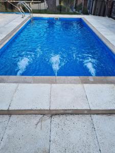 una piscina de agua azul en un patio en Dunas del Sur II en Villa Gesell