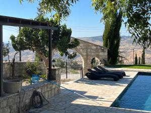 una piscina con tumbonas junto a una casa en Romanos Villa, en Pafos