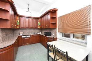 a kitchen with wooden cabinets and a table and chairs at Guesthouses Opera in Yerevan
