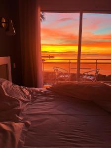 a bedroom with a bed and a window with a sunset at Hotel La Potiniere in Hyères