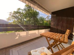 a balcony with a wooden table and a bench at FeWo in ruhiger Aussichtslage in Bad Liebenzell
