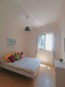 Dormitorio blanco con cama con almohadas coloridas en Apartamento con vistas en Hermigua, en Hermigua