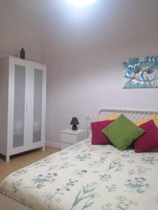 a bedroom with a bed with colorful pillows on it at Apartamento con vistas en Hermigua in Hermigua
