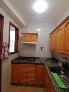 a kitchen with wooden cabinets and a counter top at Apartamento con vistas en Hermigua in Hermigua