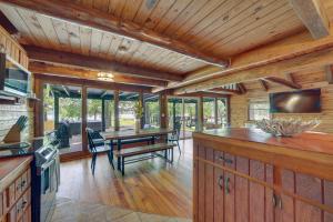 una cucina e una sala da pranzo con tavolo e TV di Modern Fairland Log Cabin with Lake Access! a Fairland