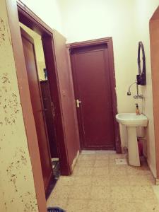 a bathroom with a door and a sink and a toilet at Marmr in Abū Turābah
