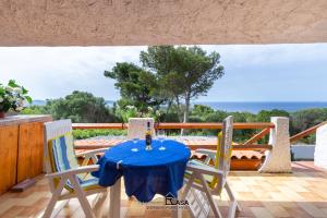 - une table et des chaises sur une terrasse avec vue sur l'océan dans l'établissement Apartments Casa Vacanze Porto Pino, à Porto Pino