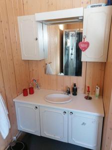 a bathroom with a white sink and a mirror at Beautiful Lavangsnes, sea , private beach, boat. 
