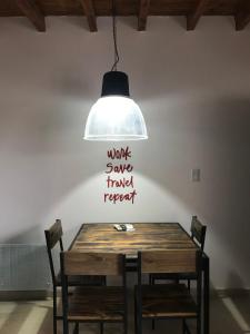 una luz colgante colgada sobre una mesa de madera con sillas en Departamento Ameghino 2do piso en San Juan