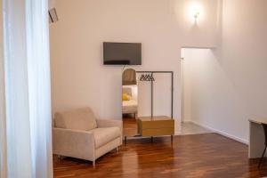 a living room with a chair and a mirror at Costa Suites in Palermo