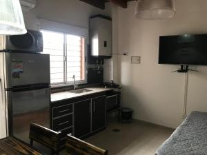 una pequeña cocina con fregadero y nevera. en Departamento Ameghino 2do piso en San Juan