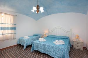 um quarto com 2 camas e um lustre em Casa Irgoli - Sardegna em Irgoli