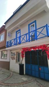 un edificio con puertas azules y un balcón con flores rojas en 5RoomsPansiyon, en Edirne