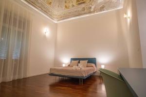 a bedroom with a bed with a blue chair and a ceiling at Costa Suites in Palermo