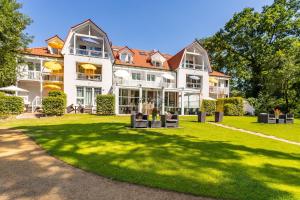 ein großes weißes Haus mit grünem Rasen in der Unterkunft Ferienwohnung Katja in der Villa Seeblick in Bad Saarow