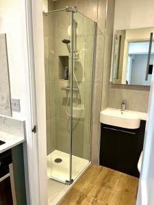 a glass shower in a bathroom with a sink at Studio at The Old Vicarage in Abingdon