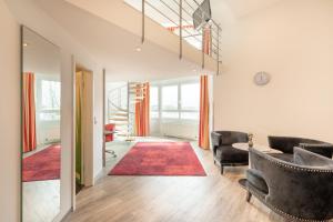 a living room with two couches and a red rug at Select Hotel A1 Bremen-Stuhr in Stuhr +49 photos
