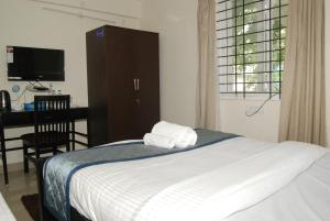 een slaapkamer met een bed met twee handdoeken erop bij The Altruist Business Stays, Manayata Tech Park in Bangalore