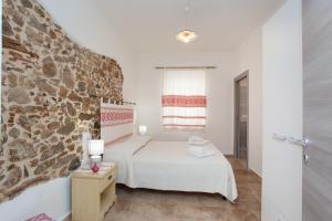 1 dormitorio con cama y pared de piedra en Appartamento Irgoli - Sardegna, en Irgoli