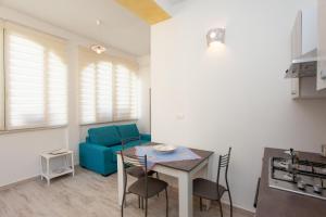 sala de estar con mesa y sofá azul en Appartamento Irgoli - Sardegna, en Irgoli