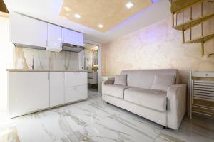 a living room with a couch and a kitchen at La magnifica napoli apartments gold house in Naples