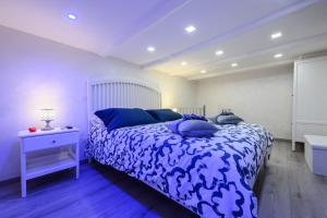 a bedroom with a blue and white bed and a sink at La magnifica napoli apartments gold house in Naples
