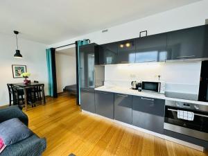 a kitchen with black and white cabinets and a table at Apartments in Panorama City on 25th floor - amazing view close to Old town in Bratislava