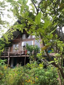 uma casa de madeira com uma varanda e algumas árvores em Hoi An Mercy homestay em Hiếu Nhơn