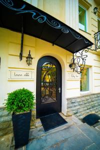 a black door on a building with a plant in front at City Inn - Boutique Hotel Tbilisi in Tbilisi City