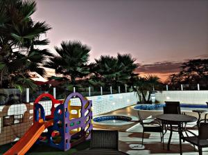 ein Spielplatz mit Rutsche sowie Tischen und Stühlen in der Unterkunft Ville de Montagne Hotel in Brumadinho