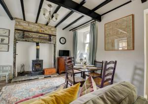 a living room with a table and a fireplace at Calverts Nook in Hawes