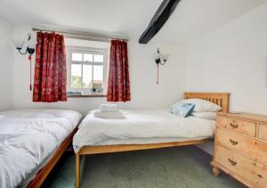 two twin beds in a room with a window at Calverts Nook in Hawes