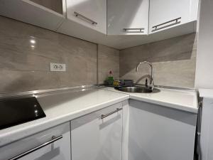 a kitchen with white cabinets and a sink at Latin Bridge Apartment Sarajevo in Sarajevo +32 photos
