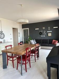 sala de estar con mesa de madera y sillas rojas en Villa Paradiso, en Campofilone