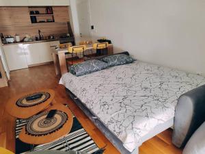 a bedroom with a large bed and a kitchen at MT One-bedroom boho apartment, Budva in Budva
