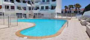 ein großes Schwimmbad vor einem Gebäude in der Unterkunft Superbe appartement à Costa Antigua in Costa de Antigua