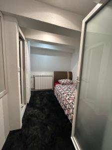 een kleine slaapkamer met een bed in een kamer bij Latin Bridge Apartment Sarajevo in Sarajevo