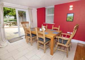 a dining room with a wooden table and chairs at Call Out Cottage in Sledmere