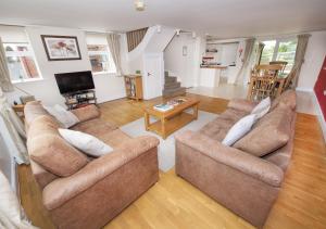 a living room with two couches and a television at Call Out Cottage in Sledmere