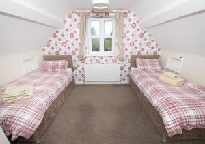 twee bedden in een kamer met een raam bij Call Out Cottage in Sledmere