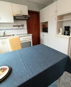 Büdingen-Ferienwohnung Bausch في بودينغن: مطبخ مع طاولة عليها قطعة قماش من الطاولة الزرقاء