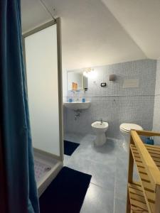 een badkamer met een douche, een toilet en een wastafel bij B&B Domus Vista in Iglesias