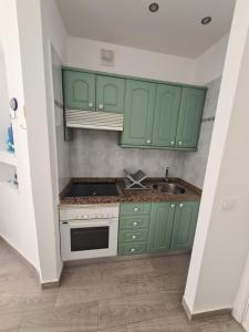 a kitchen with green cabinets and a sink at Parayso del sur in Adeje