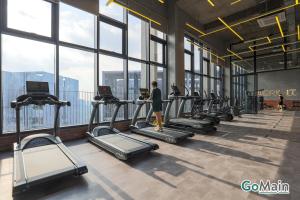 a woman walking on treadmill in a gym with windows at 2Br Family Suite MILLERZ SQUARE // KL & Free Parking in Kuala Lumpur