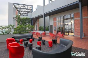 a patio with red chairs and couches on a building at 2Br Family Suite MILLERZ SQUARE // KL & Free Parking in Kuala Lumpur