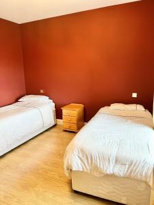 a bedroom with two beds and a wooden floor at Bridie's Place in Ballycastle