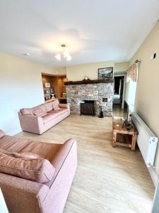 a living room with two couches and a fireplace at Bridie's Place in Ballycastle